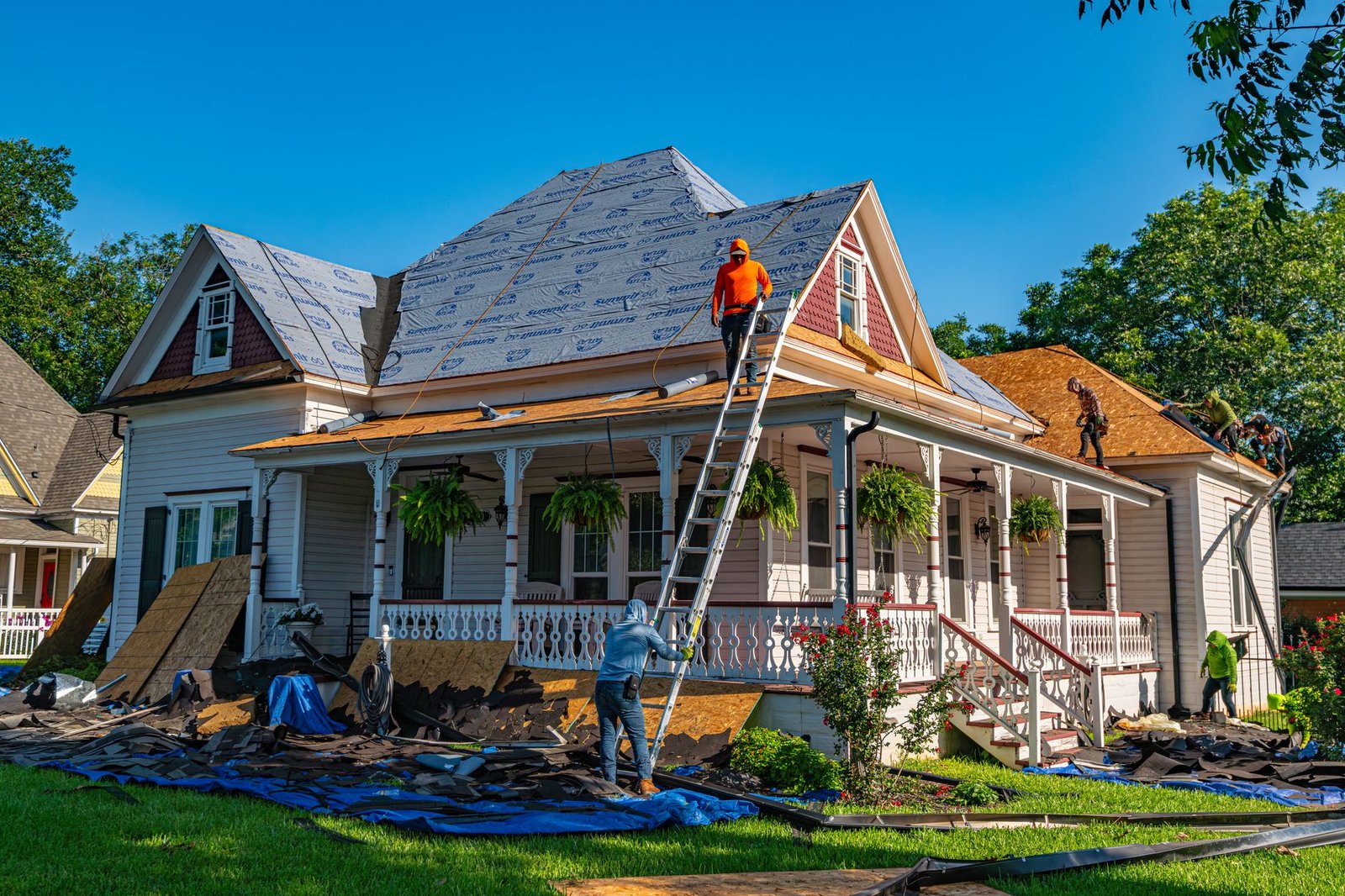 Roofers replacing a storm-damaged roof, where separate wind, hail or hurricane deductibles often apply